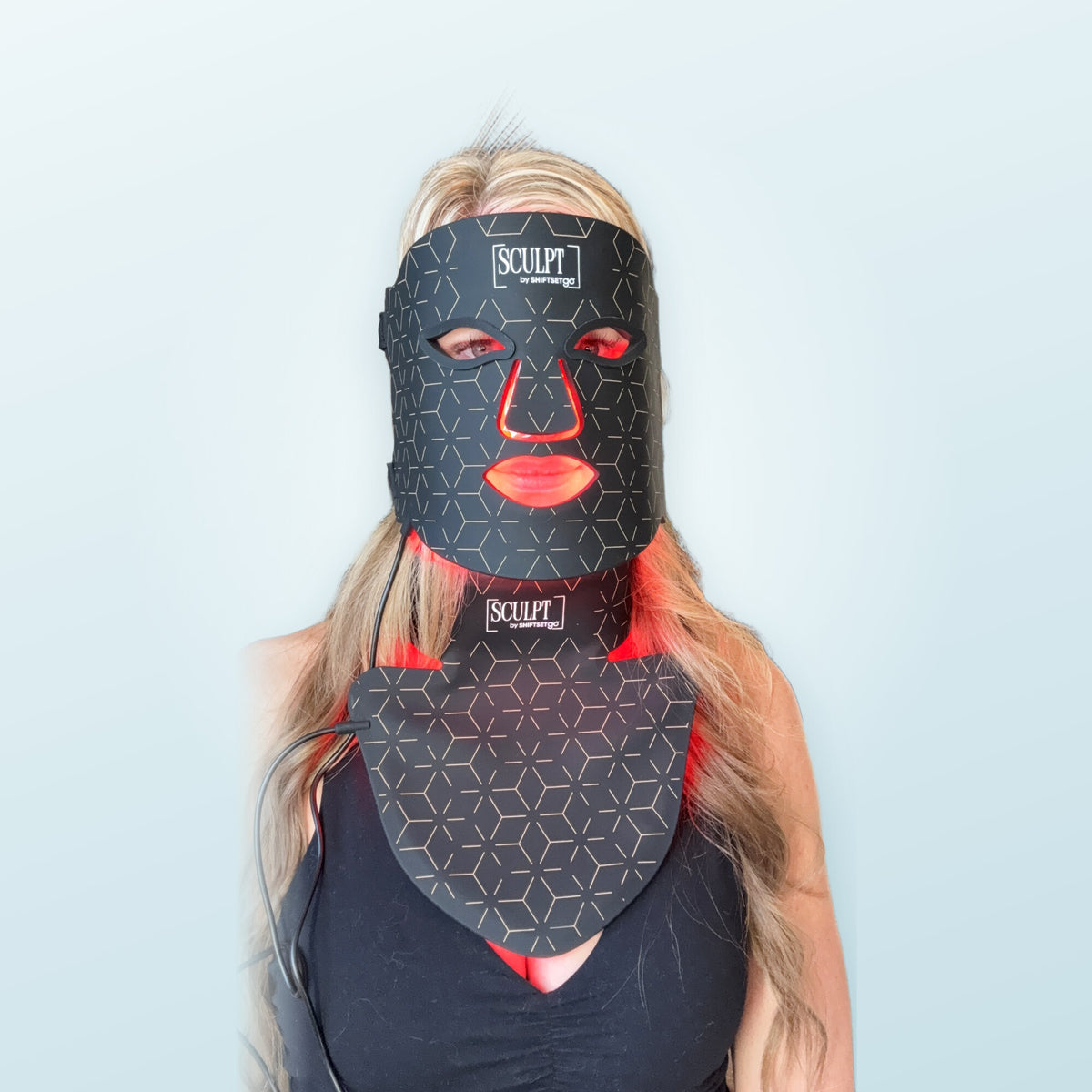 Woman wearing the SCULPT RLT Face + Neck Mask with red light on